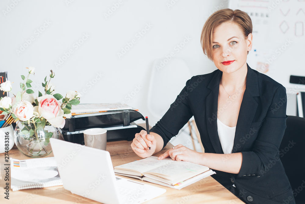 Young beautiful woman working in the office, writting Young beautiful woman working in the office, writting