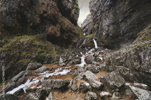 Gordale Scar waterfall through limeston cliffs near Malham Cove in the Yorkshire Dales, England. photo