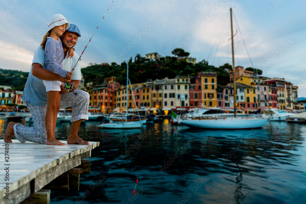 Fishing family in Portofino, Italy. Father spending summer vacation on the sea with daughter.