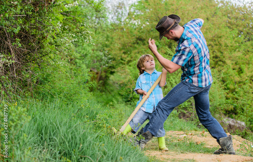 Adventure hunting for treasures. Little helper in garden. Cute child in nature having fun cowboy dad. Find treasures. Little boy and father with shovel looking for treasures. Spirit of adventures