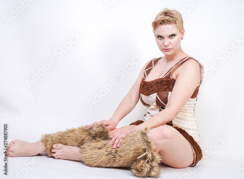 Obraz na plátně hot plus size woman in fur carnival costume of primitive man on white background in Studio