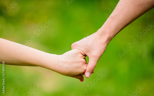 help and support. father hold his child with hand. hands together. family values and love. family bonding time. Hands together. concept of supporting. parenting and parenthood. feeling safe © be free