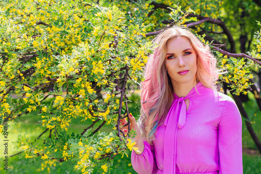Beautiful girl with colorful dyed hair and perfect makeup and hairstyle standig next blooming barberry bush with yellow flowers Beautiful girl with colorful dyed hair and perfect makeup and hairstyle standig next blooming barberry bush with yellow flowers