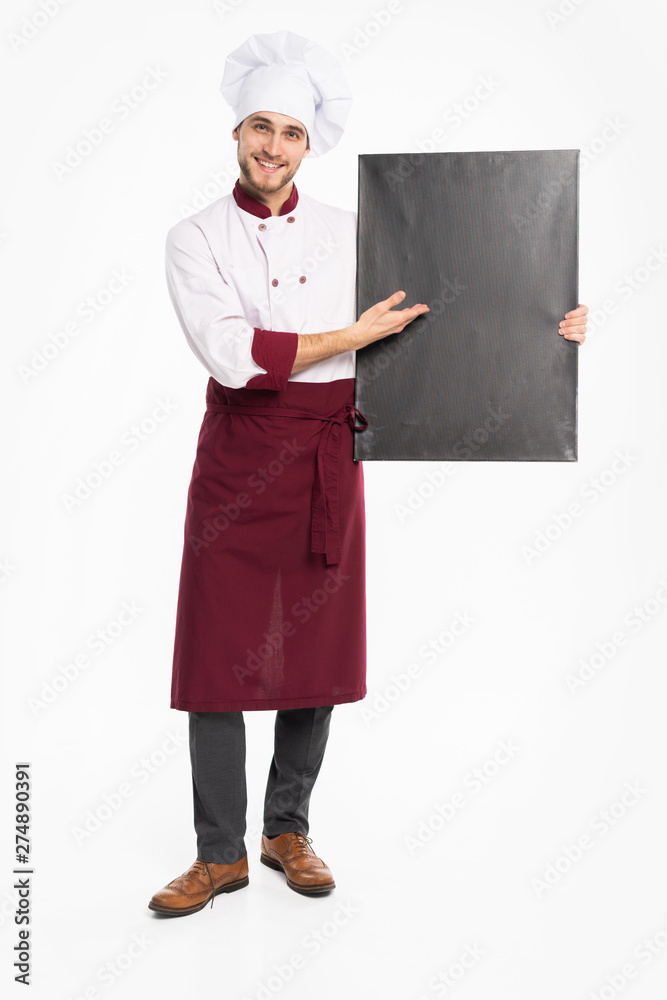 Full length portrait of a cheerful male chef cook in uniform holding blank board isolated on a white background. Full length portrait of a cheerful male chef cook in uniform holding blank board isolated on a white background.