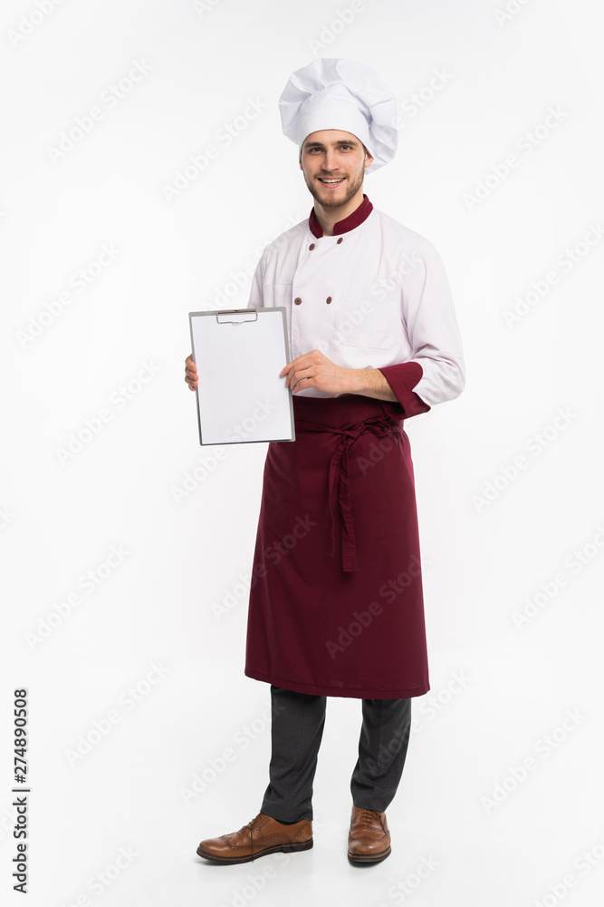 Full length portrait of a cheerful male chef cook in uniform holding blank board isolated on a white background. Full length portrait of a cheerful male chef cook in uniform holding blank board isolated on a white background.