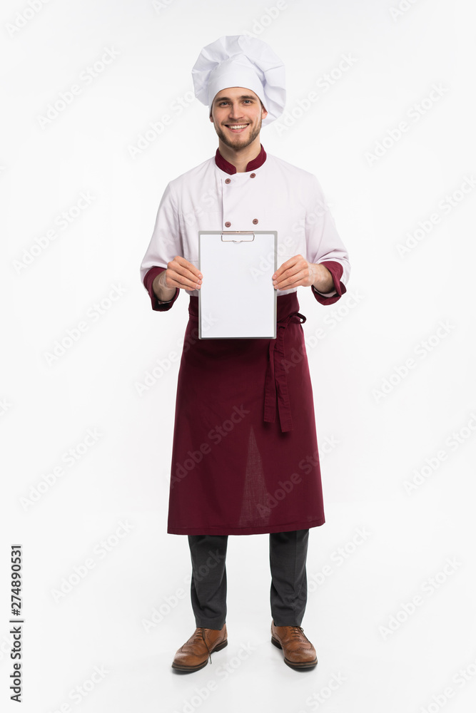 Full length portrait of a cheerful male chef cook in uniform holding blank board isolated on a white background. Full length portrait of a cheerful male chef cook in uniform holding blank board isolated on a white background.