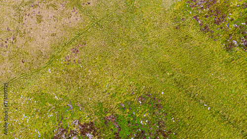 An aerial view of a mountain green slope and bog
