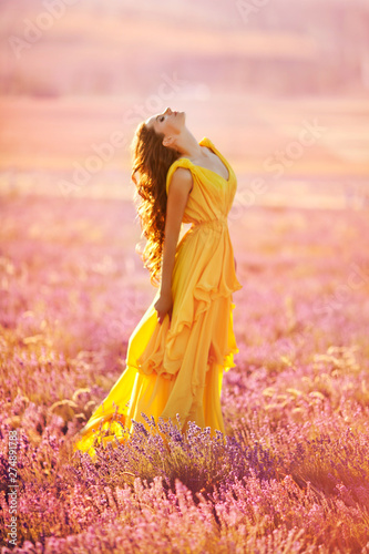 beautiful young girl walks in a field of lavender