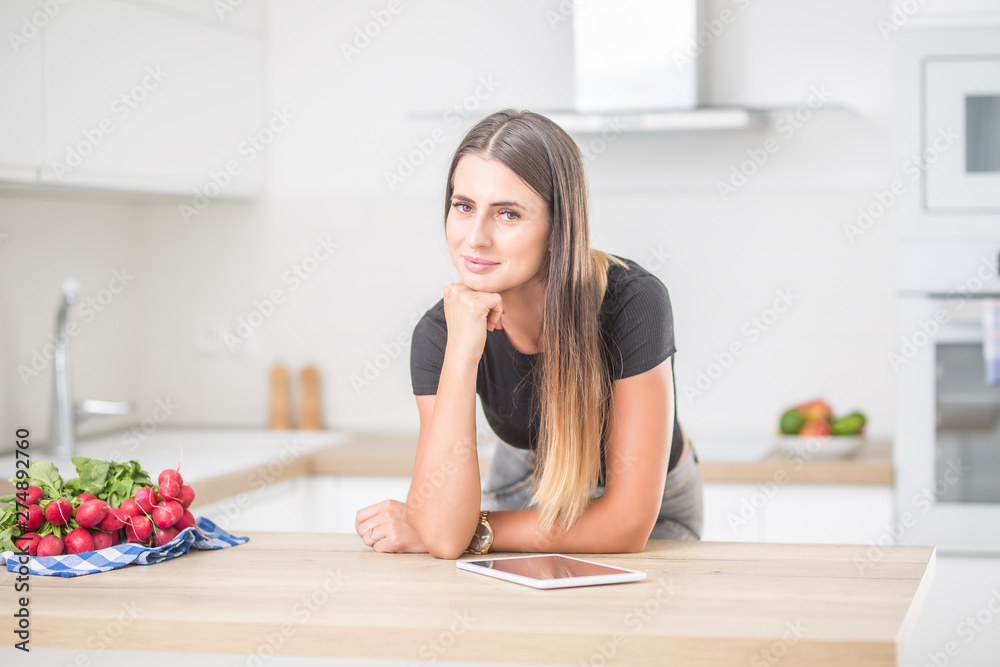 Young woman in home kitchen with tablet. Young woman in home kitchen with tablet.