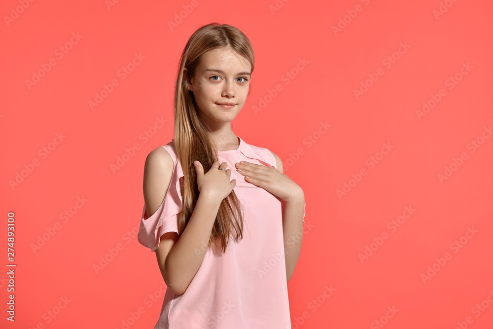 Studio portrait of a beautiful girl blonde teenager in a rosy t-shirt posing on pink background. Studio portrait of a beautiful girl blonde teenager in a rosy t-shirt posing on pink background.