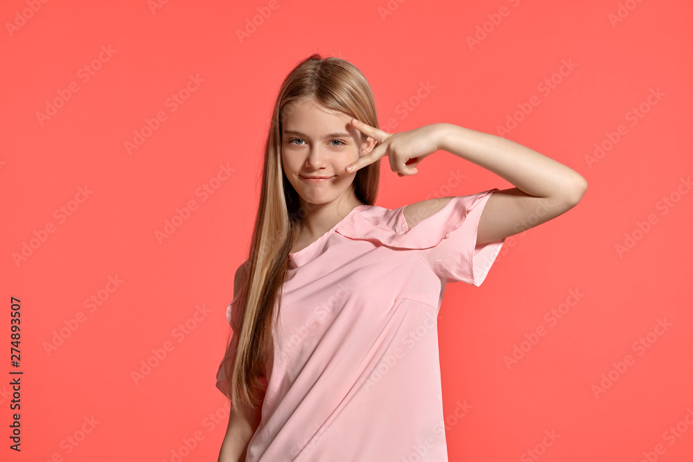 Studio portrait of a beautiful girl blonde teenager in a rosy t-shirt posing on pink background. Studio portrait of a beautiful girl blonde teenager in a rosy t-shirt posing on pink background.