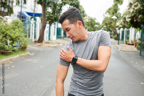 Konstfotografi Young Asian man dislocated shoulder when training outdoors