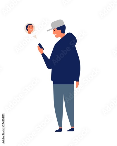 Young man or teenager wearing cap chatting online or texting on smartphone or...