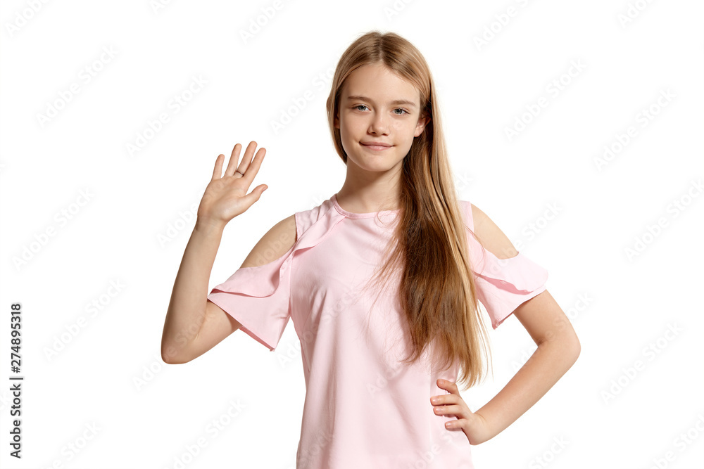 Studio portrait of a beautiful girl blonde teenager in a pink t-shirt posing isolated on white background. Studio portrait of a beautiful girl blonde teenager in a pink t-shirt posing isolated on white background.