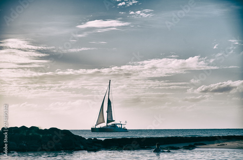 Sailing catamaran along island coast