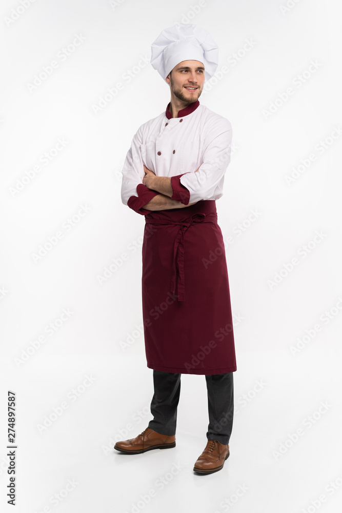 Positive handsome chef cook in beret and white outfit isolated on white background.