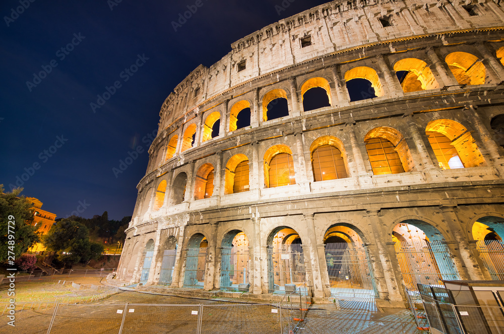 ROME, ITALY - JUNE 2014: Tourists visit Colosseum at night. The city attracts 15 million people annually