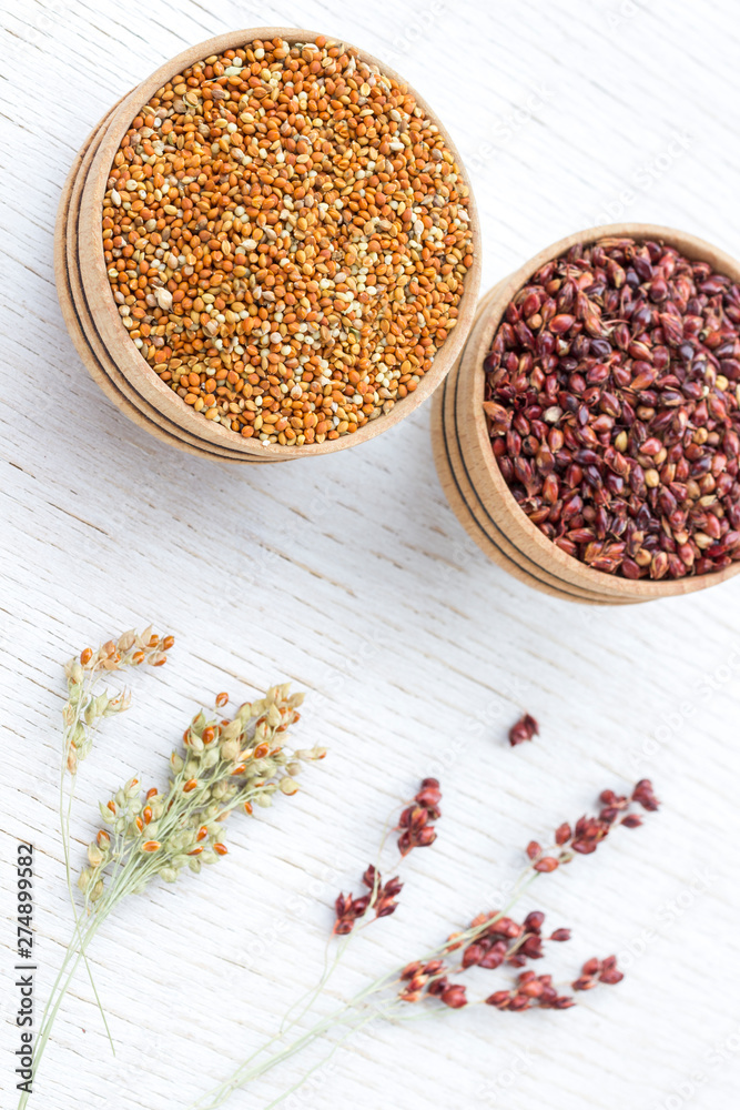 Two boxes with red and yellow millet. Sprigs of millet. White background Two boxes with red and yellow millet. Sprigs of millet. White background