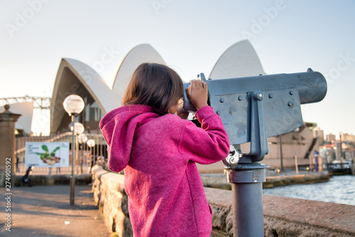 Photography Happy smiling young girl visiting Sydney looking into a telescope