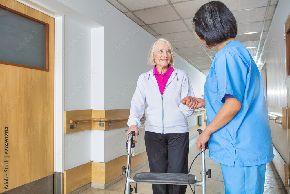 Caregiver assisting senior retired woman at hospital Caregiver assisting senior retired woman at hospital