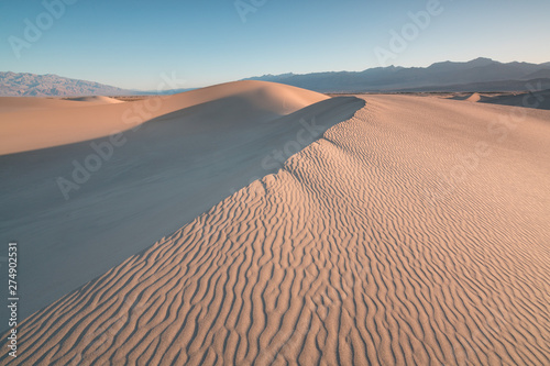 Early Morning Sunlight Over Sand Dunes And Mountains At  Mesquite flat dunes  Death Valley National Park  California USA Stovepipe Wells sand dunes  very nice structures in sand Beautiful background