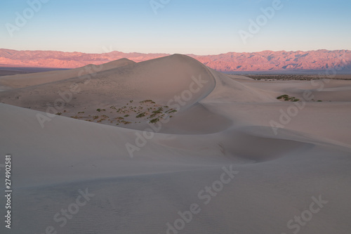 Early Morning Sunlight Over Sand Dunes And Mountains At Mesquite flat dunes, Death Valley National Park, California USA Stovepipe Wells sand dunes, very nice structures in sand Beautiful background