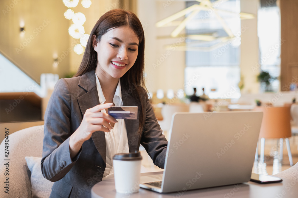 Asian businesswoman using credit card and mobile phone for online financial payment and shopping Asian businesswoman using credit card and mobile phone for online financial payment and shopping