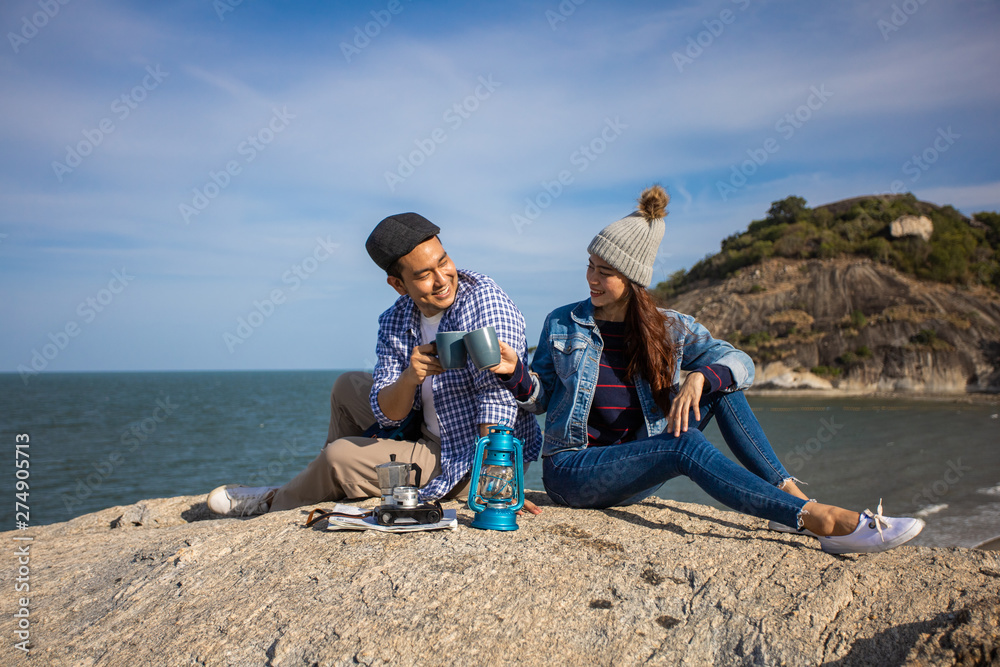 Asian couple camping travel on the hill near the beach