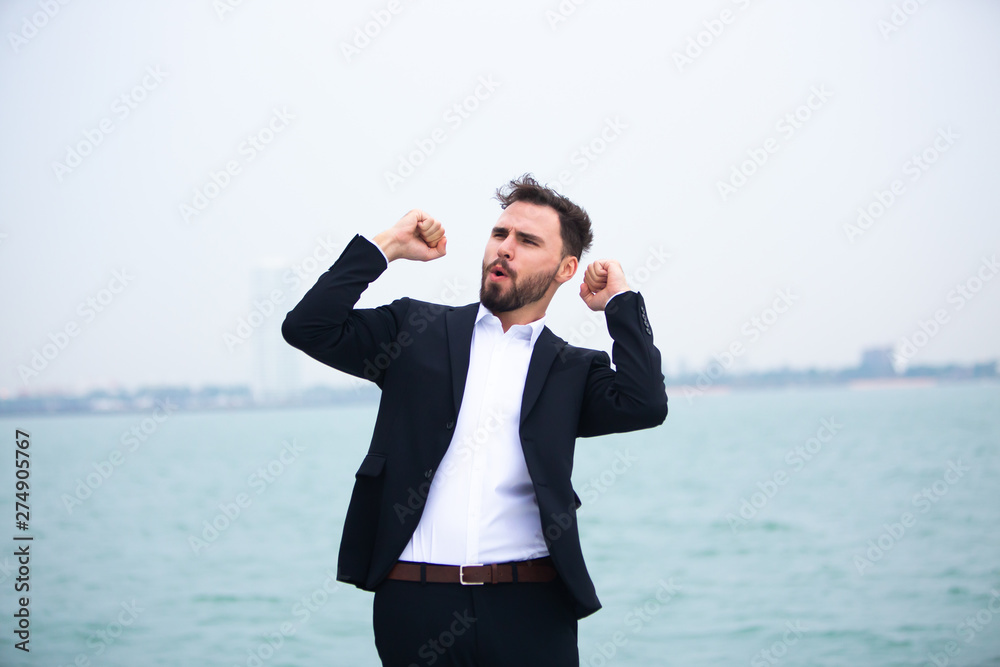 Portrait of a positive young businessman feeling very happy on the vacation sailboat yacht standing on a deck Portrait of a positive young businessman feeling very happy on the vacation sailboat yacht standing on a deck