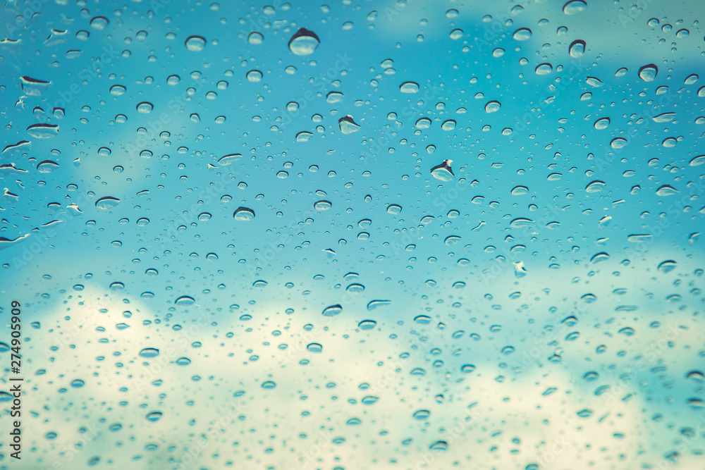 Rain drops, water drops of rain on a window glass. blurred lights city