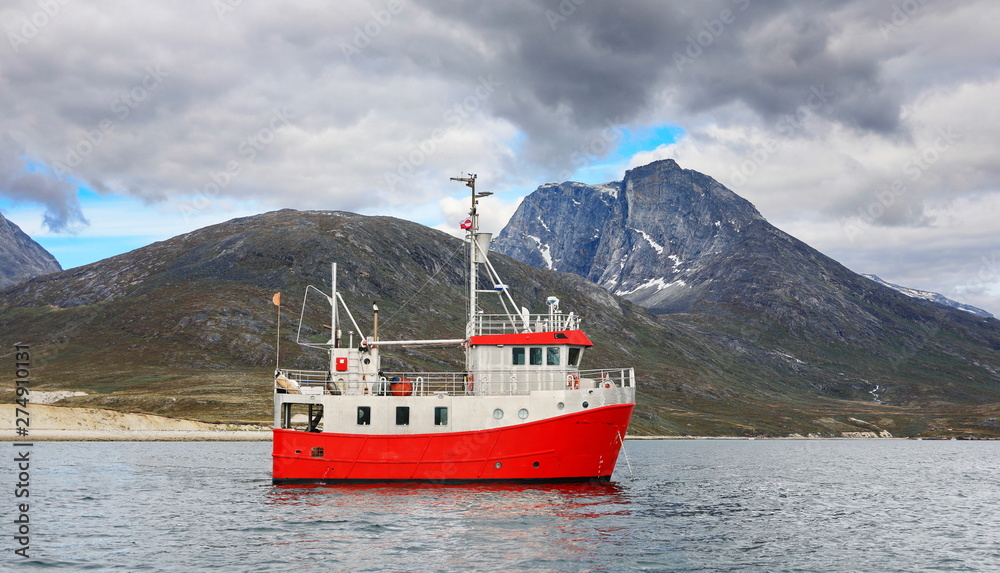 Naklejka premium Boat and landscapes of Greenland, Nuuk fjord, ocean with mountains background