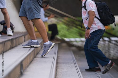 Close up of legs and shoes walking on street in the city