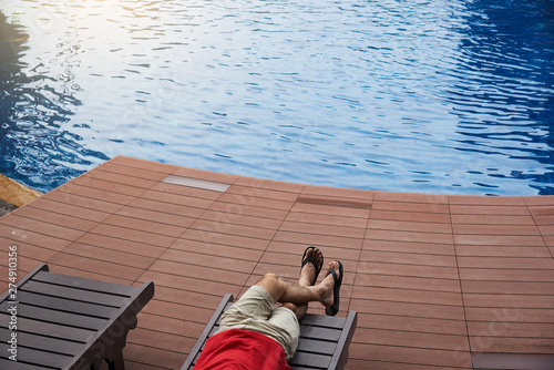 A man sitting near the swinmming pool photo