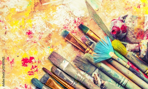 Row of artist paint brushes on art background