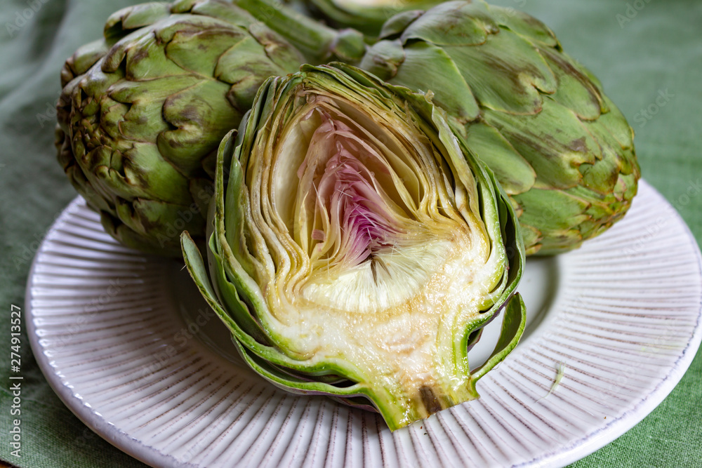 Obraz premium Heads of fresh uncooked artichoke flowers close up