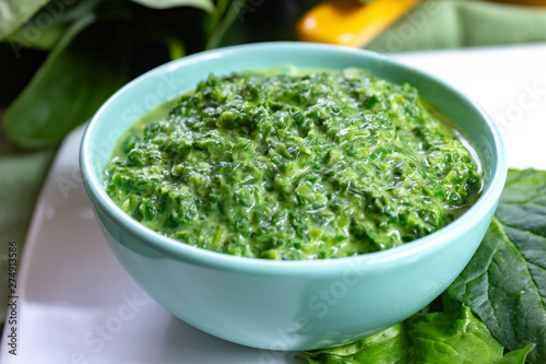 Healthy vegetarian or vegan food, cooked green spinach with cream, ingredient for many dishes like pasta, ravioli or soup
