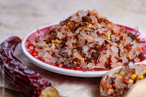 Gross sea salt mixed with dried red hot chili pepper, colorful seasoning close-up