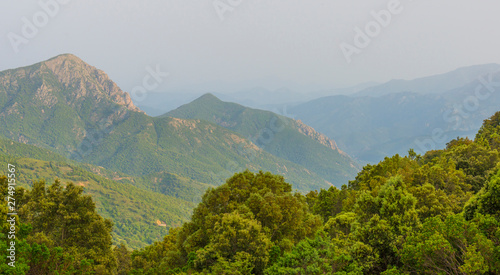 Scenic landscape of green hills and rocky mountains of the island of Sardinia in spring