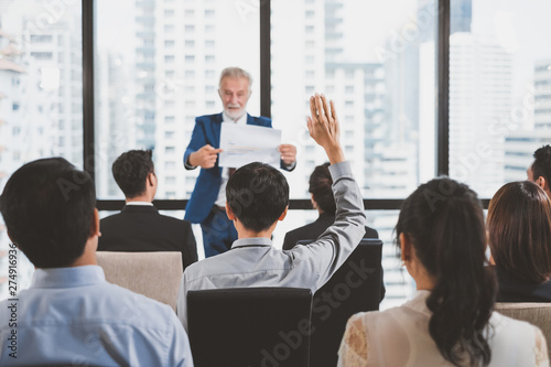 Group of business people raise hands up to ask question and answer to speaker in the meeting room seminar