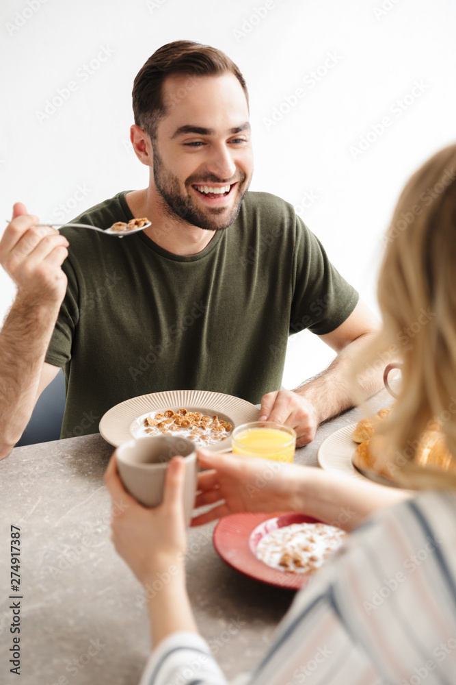 Happy young loving couple posing at the kitchen at home have a breakfast. Happy young loving couple posing at the kitchen at home have a breakfast.