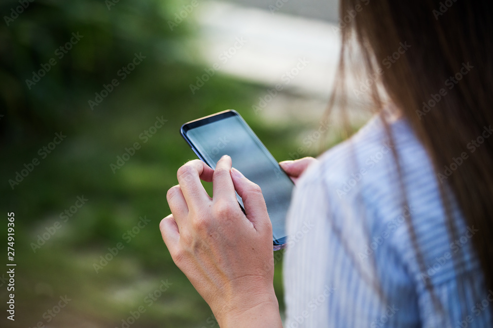 Close up of women's hands holding cell telephone with blank copy space scree for your advertising text message or promotional content Close up of women's hands holding cell telephone with blank copy space scree for your advertising text message or promotional content