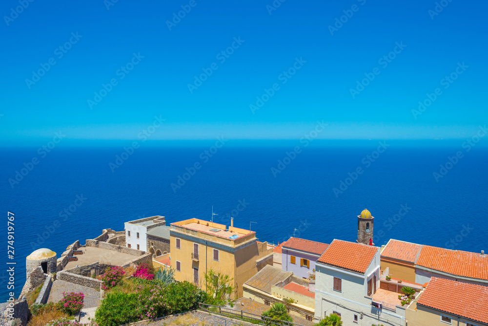View of the town of Castelsardo on a hill and along the sea in sunlight in spring