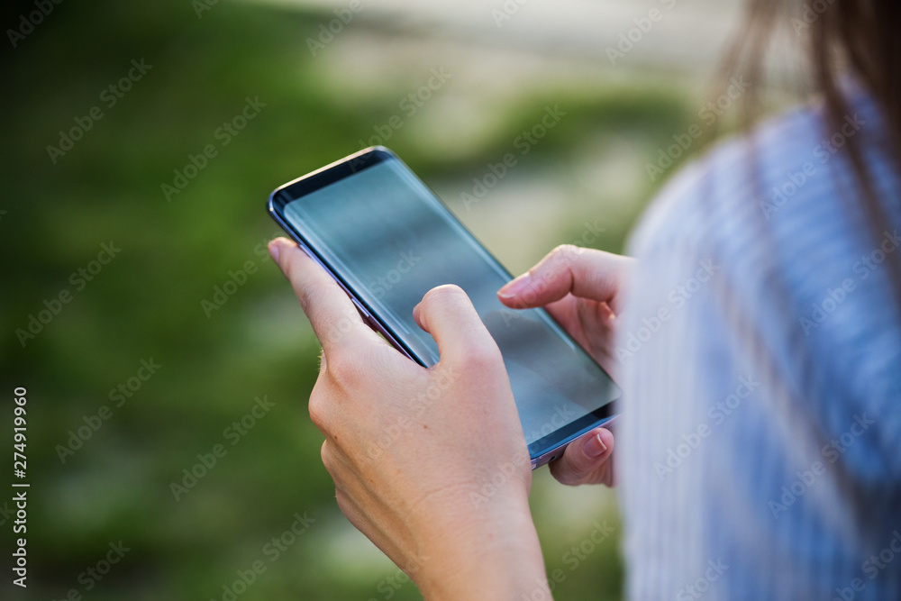 Close up of women's hands holding cell telephone with blank copy space scree for your advertising text message or promotional content