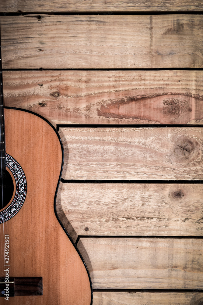 Fototapeta premium Acoustic guitar on vintage style wood background. Copy space with musical guitar instrument