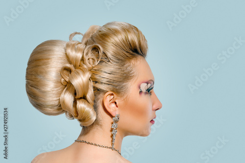 Beautiful bride with fashion wedding hairstyle on blue color background