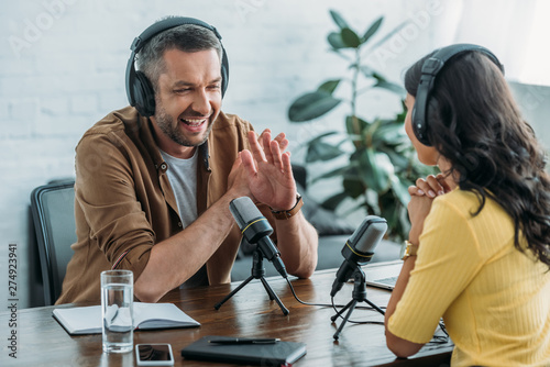 cheerful radio host showing no sign while recording podcast with colleague