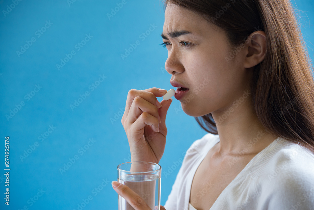 Young woman taking medicine pill after doctor order Young woman taking medicine pill after doctor order
