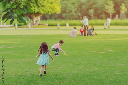 Kid enjoy to playing with little ball on green field