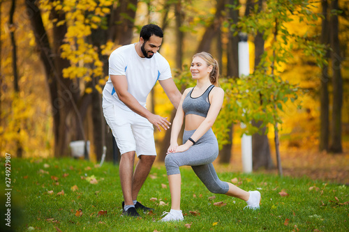 Fitness. Personal Trainer Takes Notes While Woman Exercising Outdoor