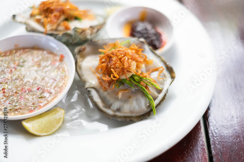 Fresh Oyster Thai style with spicy sauce serve with Chili paste, crispy shallots, garlic and fresh vegetable.